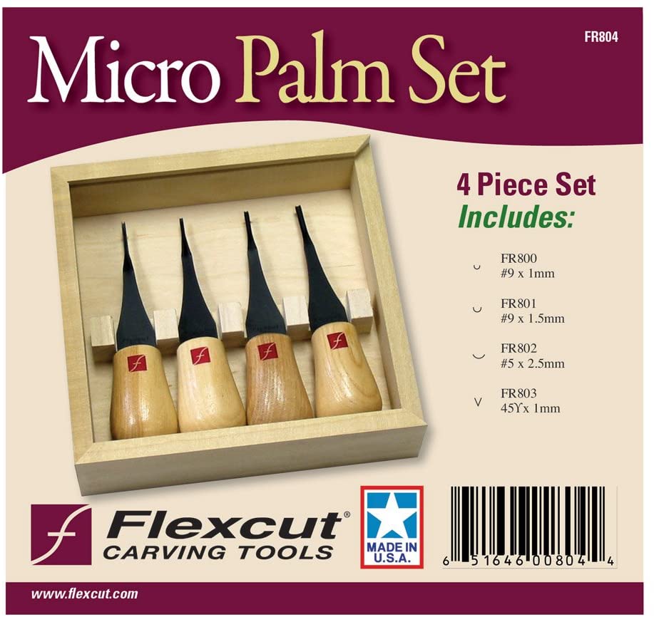 A wooden tray displays the Flexcut Micro Palm Set by FLE, containing four wood carving tools with ergonomic handles and high carbon steel blades. The label lists tool types, and branding plus Made in USA are shown.