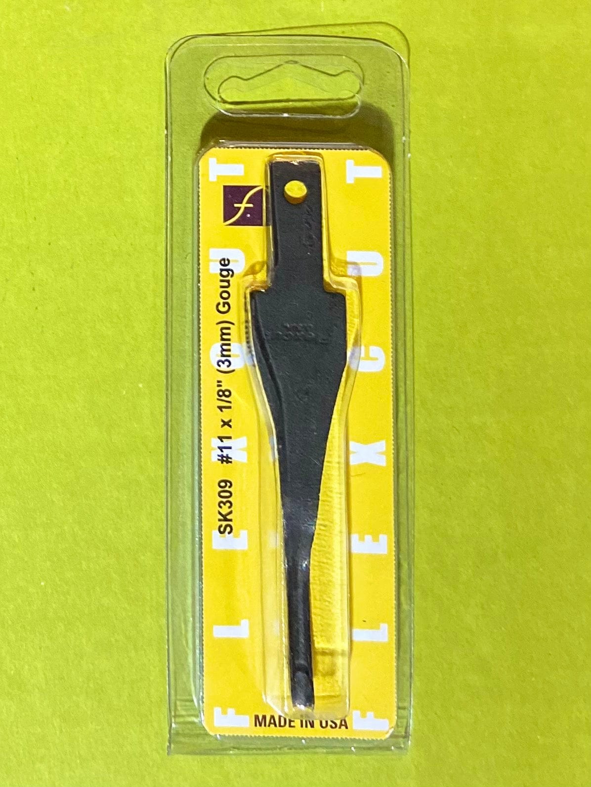 A FLE Flexcut Gouge Blade (SK309, 1/8 / 3mm) in original yellow and clear plastic packaging, shown on a yellow background.