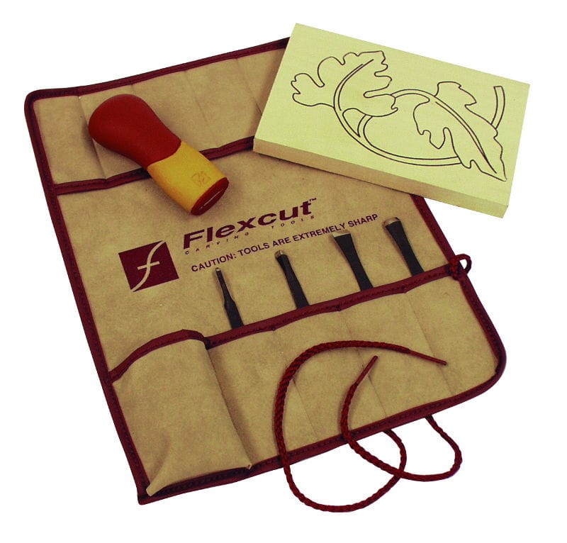 The FLE Craft Carver Set 5-Piece includes five carving blades, a red and yellow handle, and a leaf-pattern project blank in a tan roll-up pouch partially unrolled with the red tie cord showing.