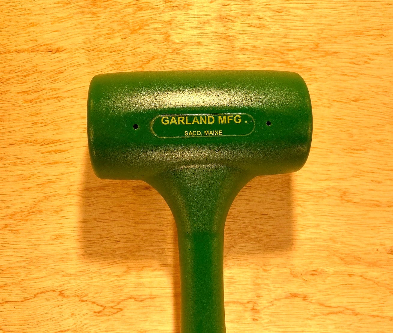 Garland Dead Blow Mallet by GAM, featuring a cast polyurethane head with a dead-blow design, labeled "Garland MFG, Saco, Maine," on a wooden background.