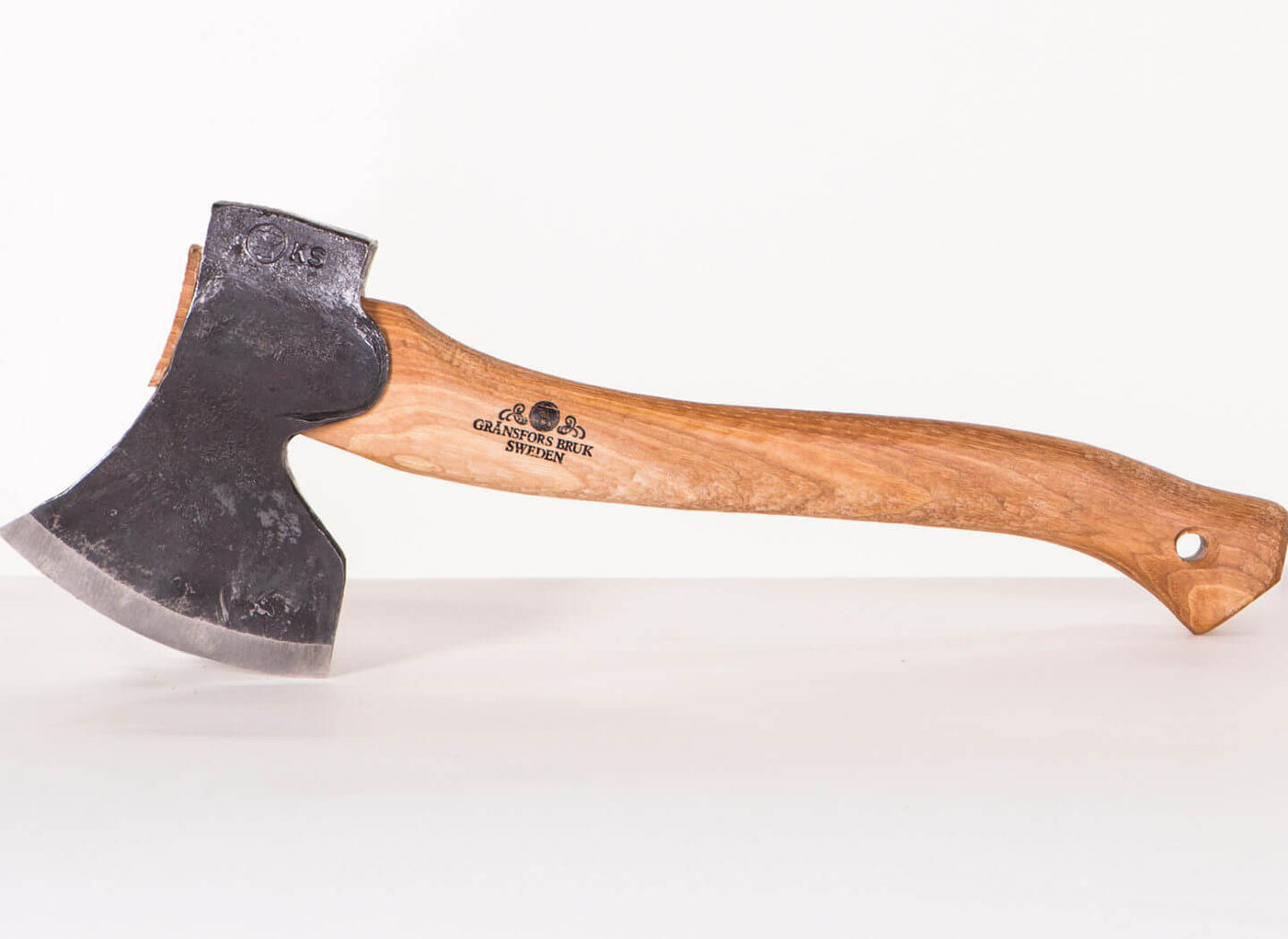 A GRF Gransfors Bruk Large Swedish Carving Axe, featuring a wooden handle and black metal head, is set against a neutral background.