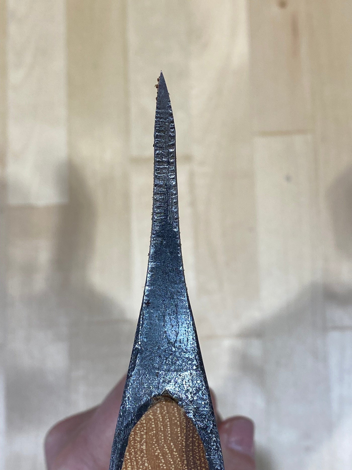 Close-up of a Gransfors Bruk Large Swedish Carving Axe by GRF, with a sharp edge held over wood, reminiscent of traditional Swedish carving techniques.