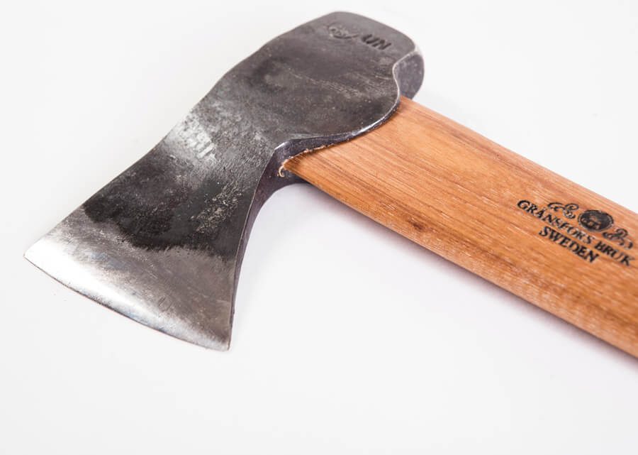 A close-up of the Gransfors Bruk Hunters Axe 418 by GRF shows its polished wooden handle and engraved “GRÄNSFORS BRUK SWEDEN” near the end, designed for skinning or chopping wood, set against a white background.