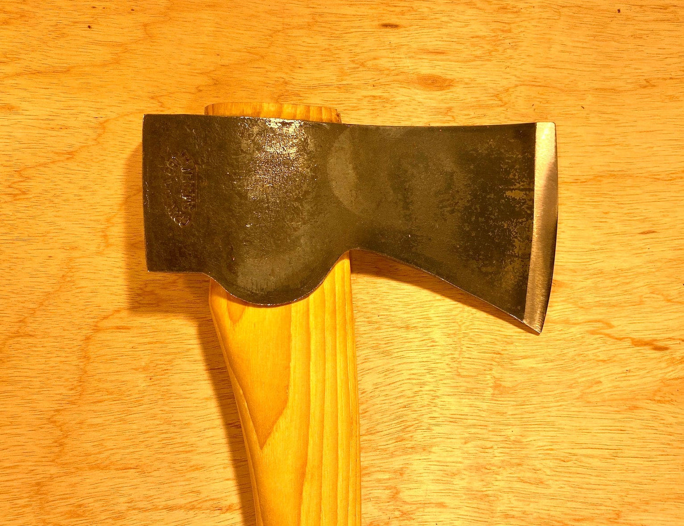 A GRF Gransfors Bruk Scandinavian Forest Axe—esteemed as a professional forestry tool—rests on a wood surface, highlighting its metal axe head and robust wooden handle perfect for felling and limbing.