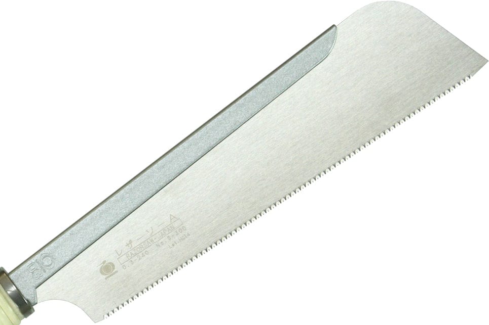 A close-up of the BBT Dozuki Cross Cut Razorsaw shows its straight, thin blade with fine serrated teeth—ideal for precise carpentry finishing. The blade features etched writing and symbols on its surface.