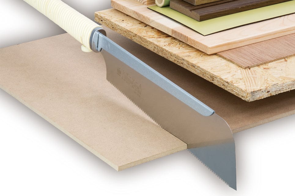 A BBT Dozuki Cross Cut Razorsaw with a white-wrapped handle sits on wood and laminate boards, highlighting its sharp, thin blade—ideal for precise finishing and carpentry cuts.