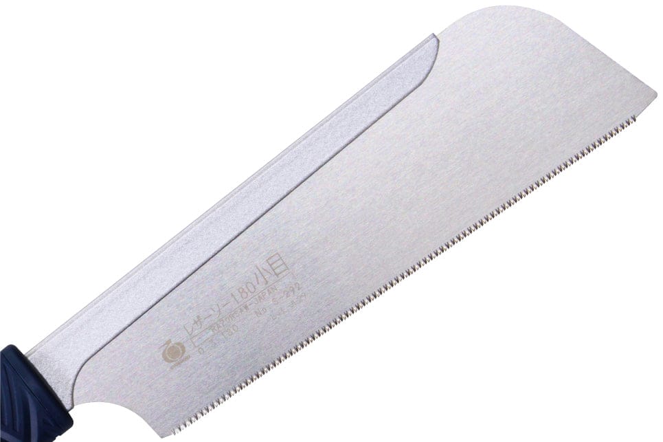 A detailed close-up of a Japanese pull saw, specifically the Gyokucho 180 Komame Razorsaw from BBT, highlights its fine teeth and straight blade with a curved tip. The handle is partially visible on the left side, exemplifying its precision as an exceptional fine woodworking tool.