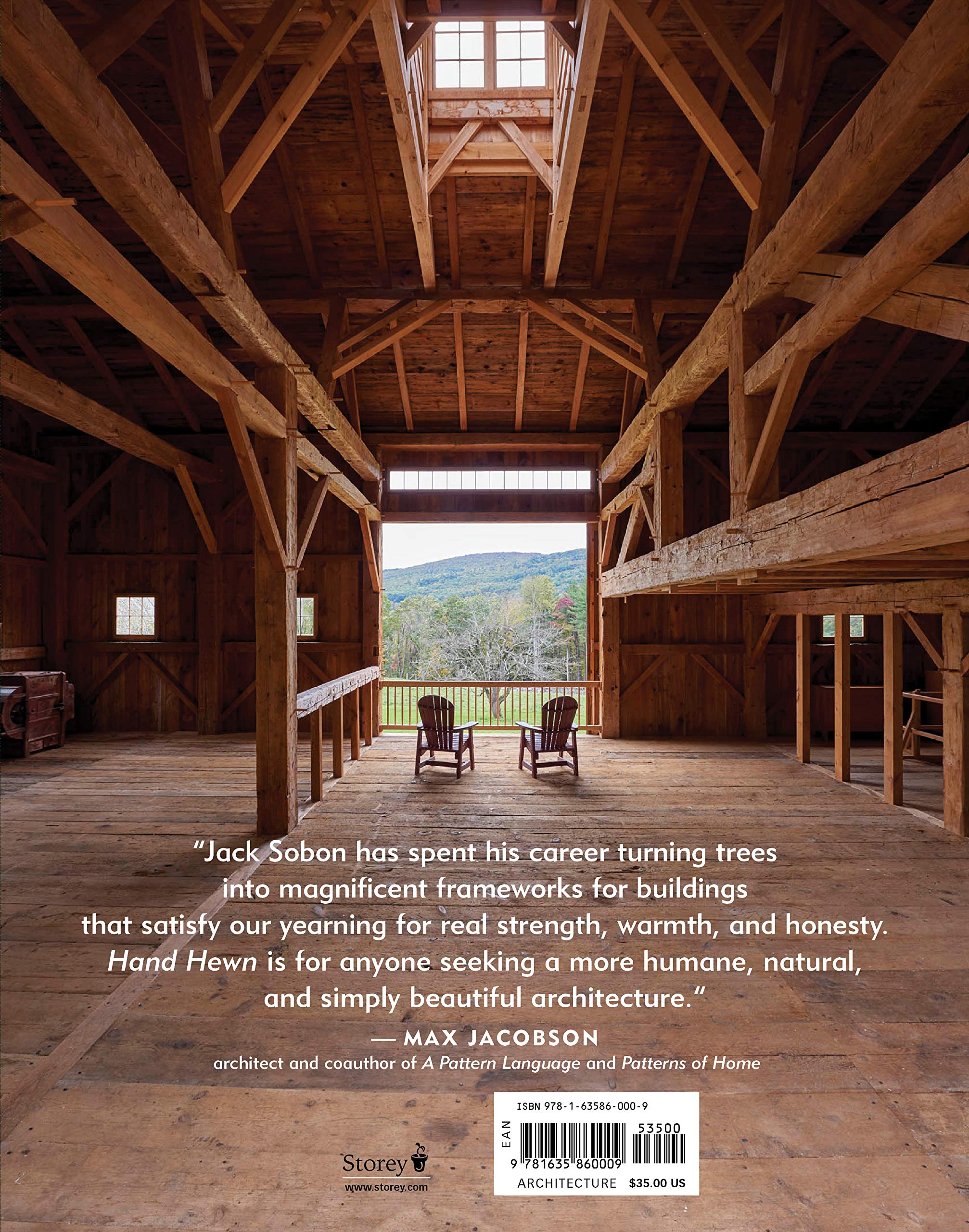 The barn’s exposed beams, crafted with traditional timber framing, echo the craftsmanship celebrated in "Hand Hewn: The Traditions, Tools, and Enduring Beauty of Timber Framing" by Ingram Content Group. Two chairs face the scenic view from the porch.