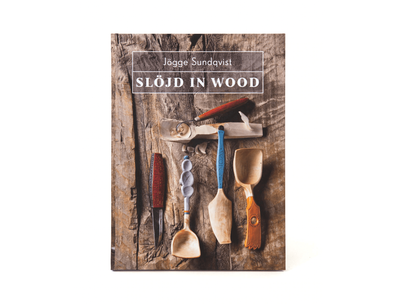 Cover of "Slöjd in Wood" by LAP, featuring Jögge Sundqvist's exquisite woodworking tools and beautifully crafted wooden spoons against a rustic wooden backdrop.