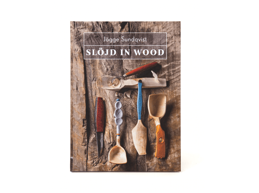 Cover of "Slöjd in Wood" by LAP, featuring Jögge Sundqvist's exquisite woodworking tools and beautifully crafted wooden spoons against a rustic wooden backdrop.