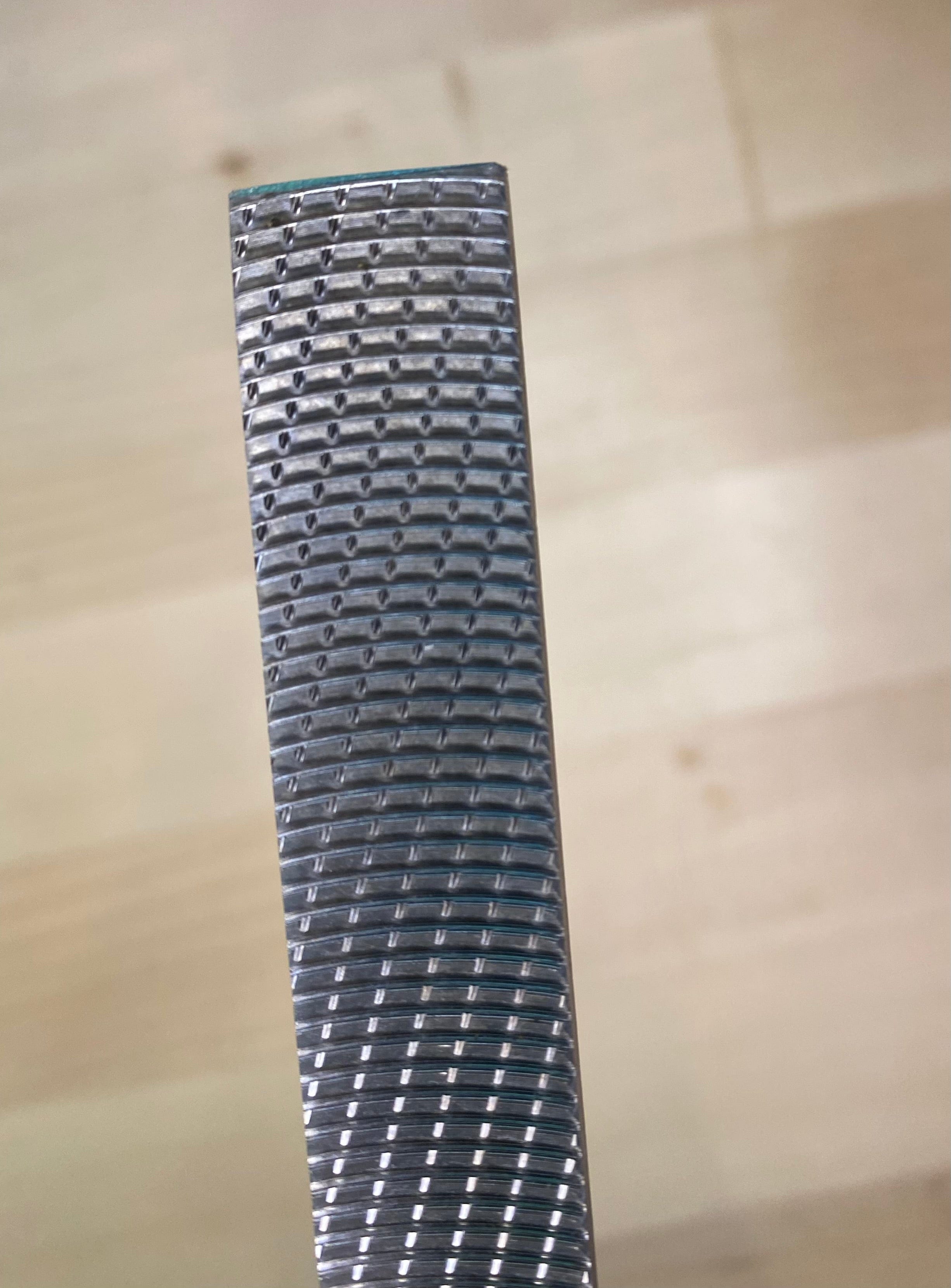 Close-up of a MARU Iwasaki Wood File, highlighting its textured, grooved surface that exemplifies innovative Japanese design for fast cutting action, set against a light wooden background.