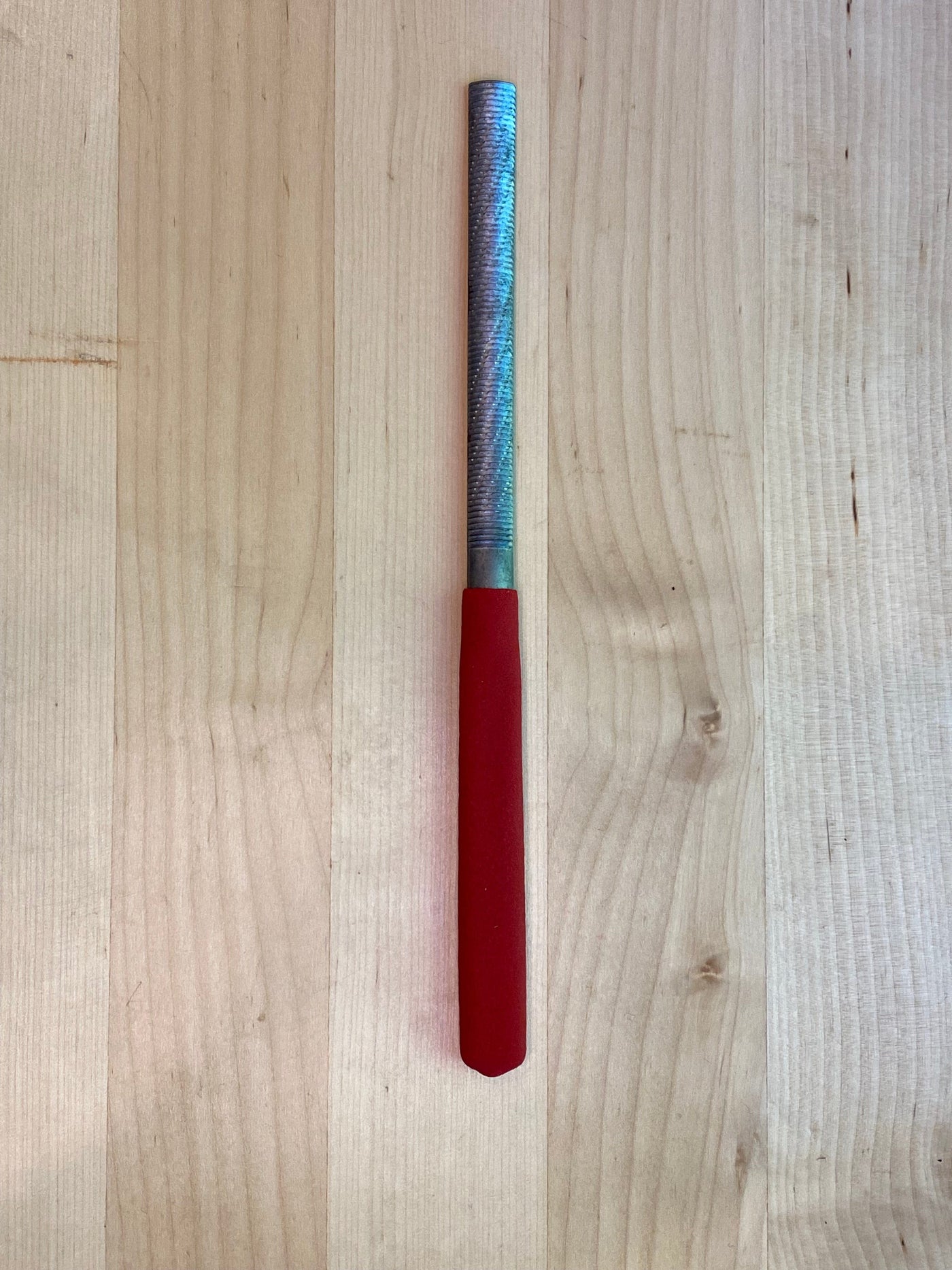 The MARU Iwasaki Half Round Ex Fine W/Grip, a woodworker's essential tool, rests on a wooden surface.