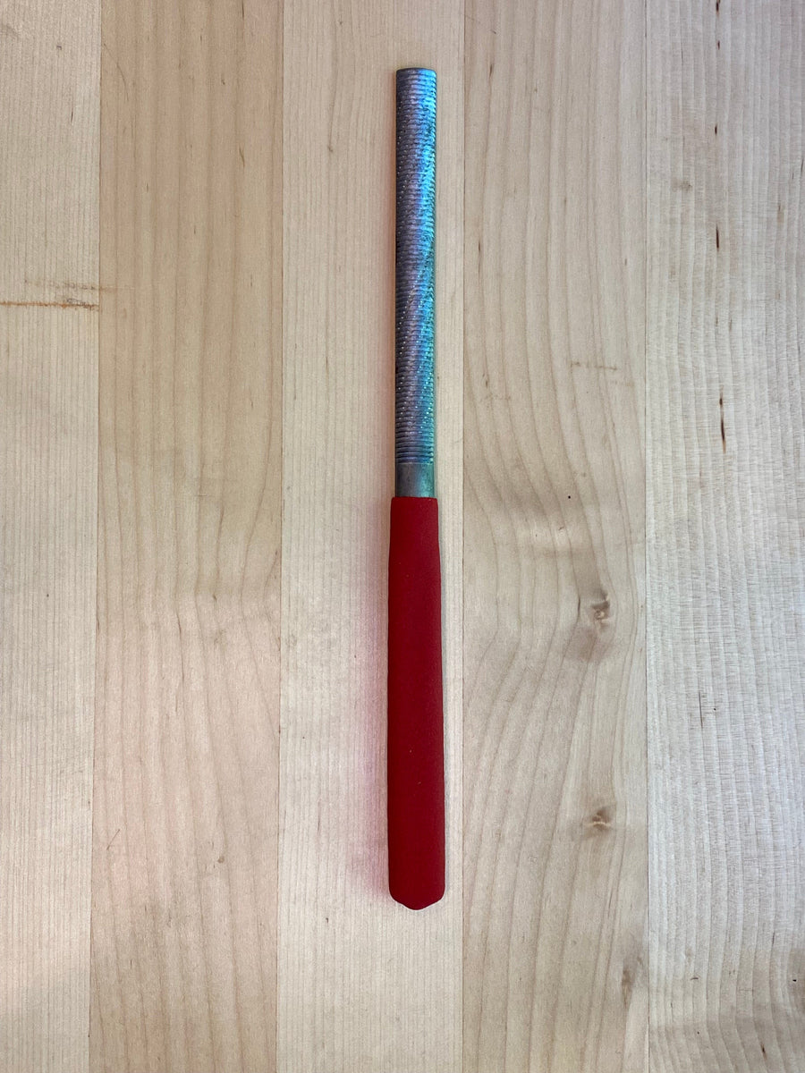 The MARU Iwasaki Half Round Ex Fine W/Grip, a woodworker's essential tool, rests on a wooden surface.