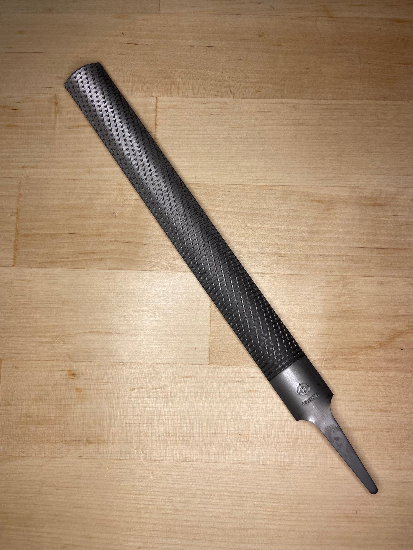 The MARU Iwasaki Half Round Medium Cut Wood File, featuring a textured surface and flat handle, rests on a light wooden surface.