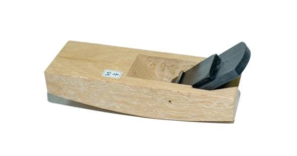 The Compass Plane by MARU is a wooden hand plane with a metal blade, crafted from Japanese White Oak and featuring hand-forged lamination, designed for smoothing and shaping wood surfaces.