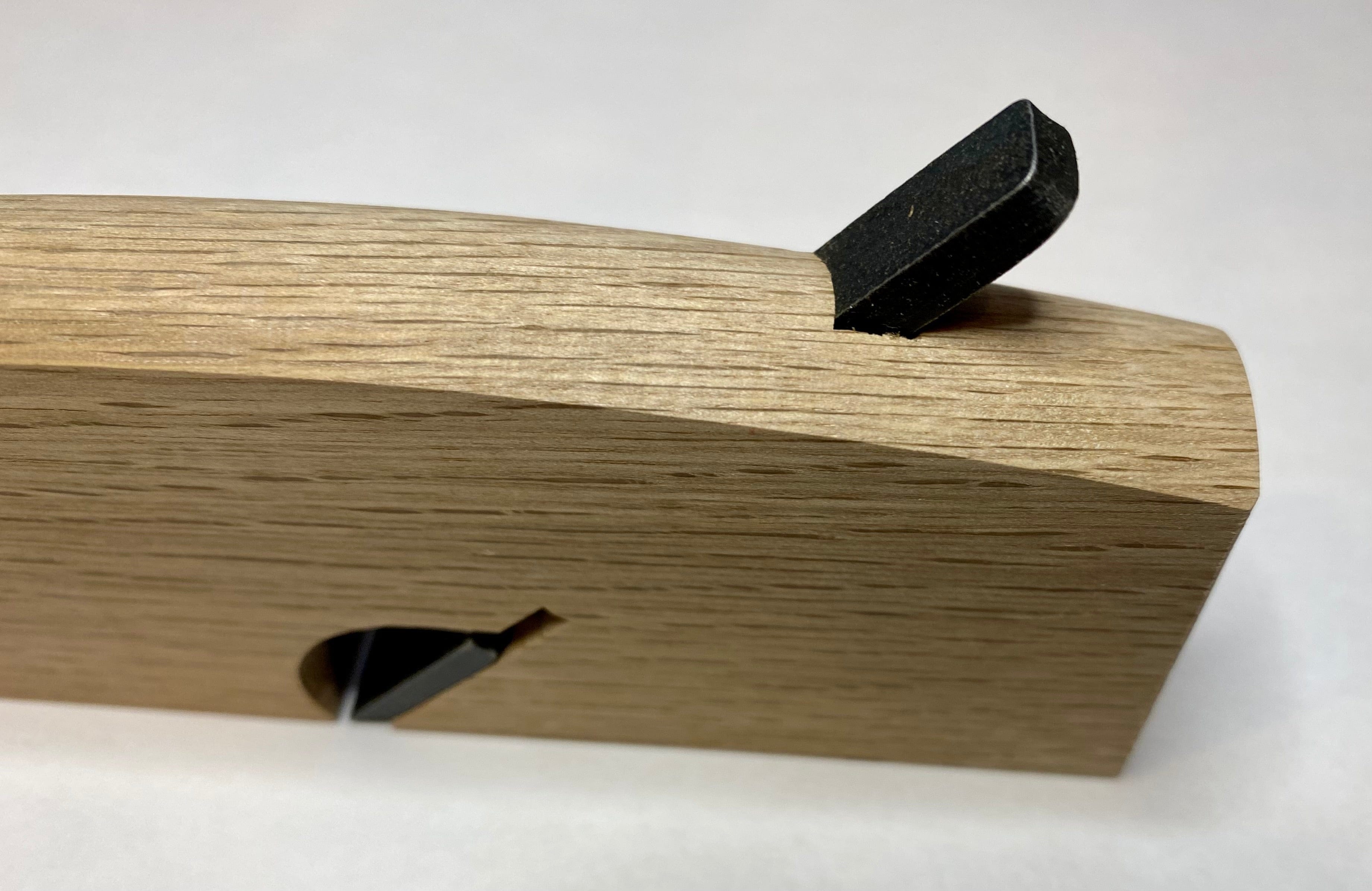 Close-up of the maru Japanese Rabbet Plane-White Oak, showcasing its visible metal blade, smooth finish, and triangular opening for shaving expulsion.