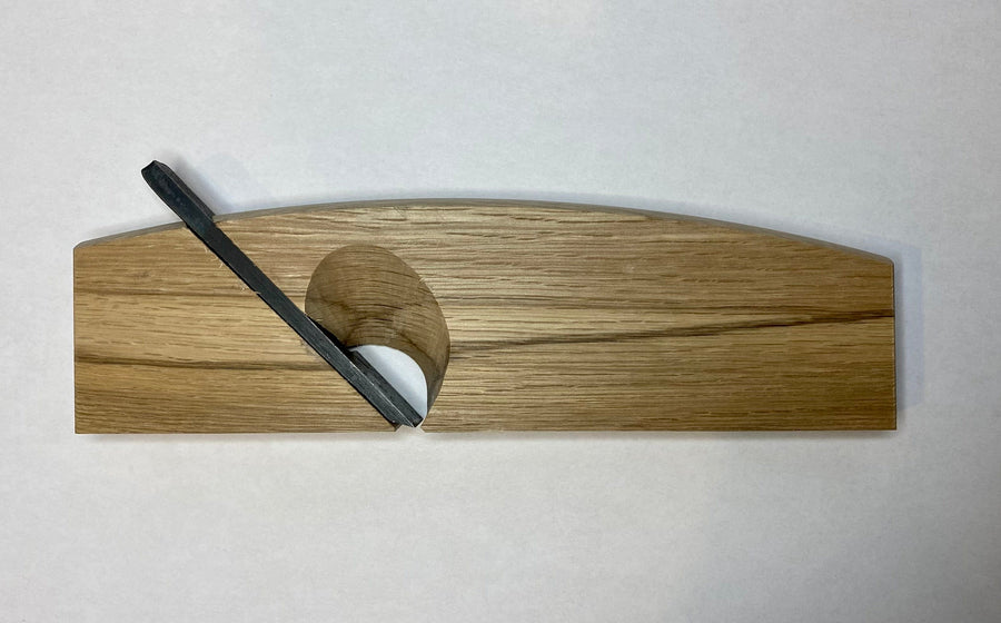 The maru Japanese Rabbet Plane-White Oak, expertly designed with a metal blade set at an angle, is showcased elegantly on a white background, exemplifying essential craftsmanship.