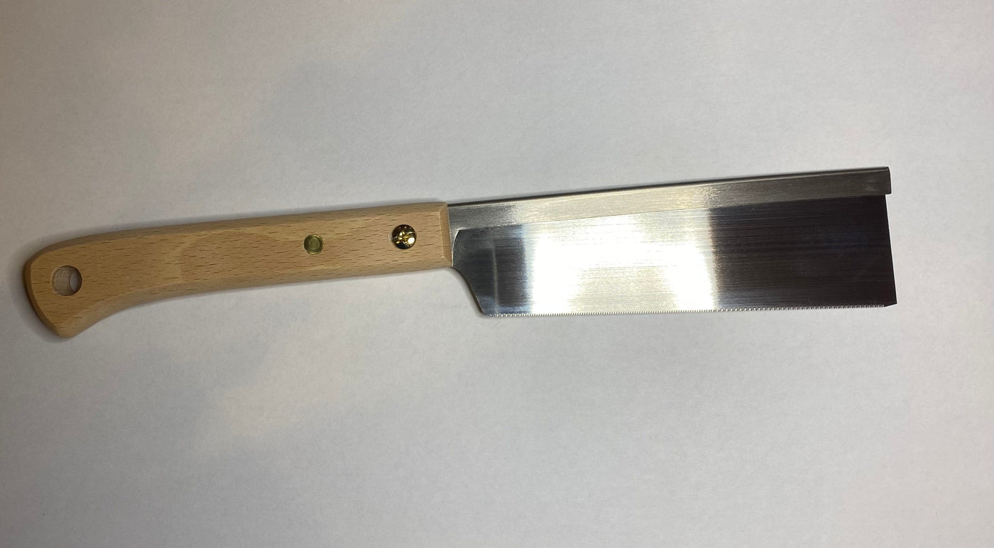 A MARU Japanese Craft Saw with a beech wood handle and shiny metallic blade rests on a flat white surface, showcasing exquisite craftsmanship.