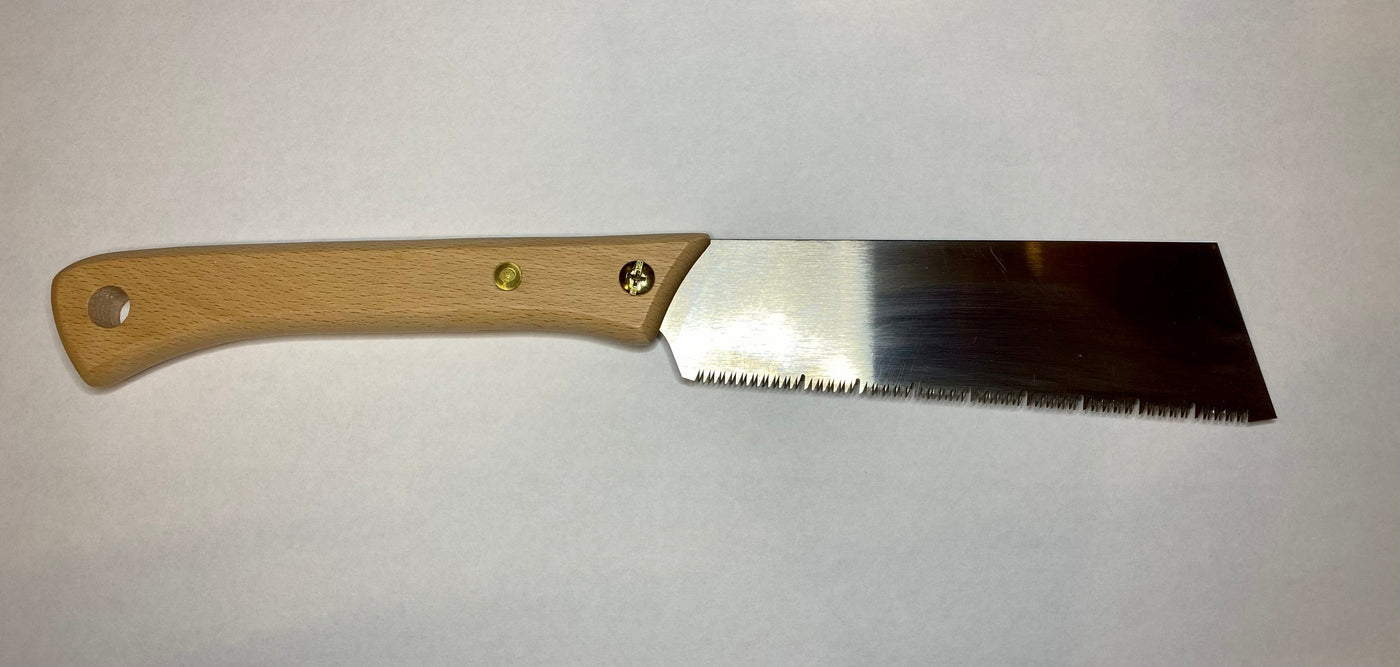 A MARU Japanese Craft Saw with a beech wood handle and metal blade rests gracefully on a plain white surface.