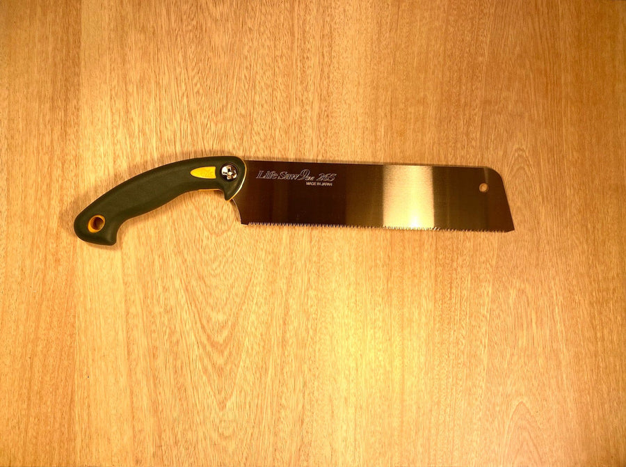 The Life Saw 265 By Z-Saw from MARU, featuring a black and yellow handle and designed for precise pull stroke cutting, rests on a wooden surface.