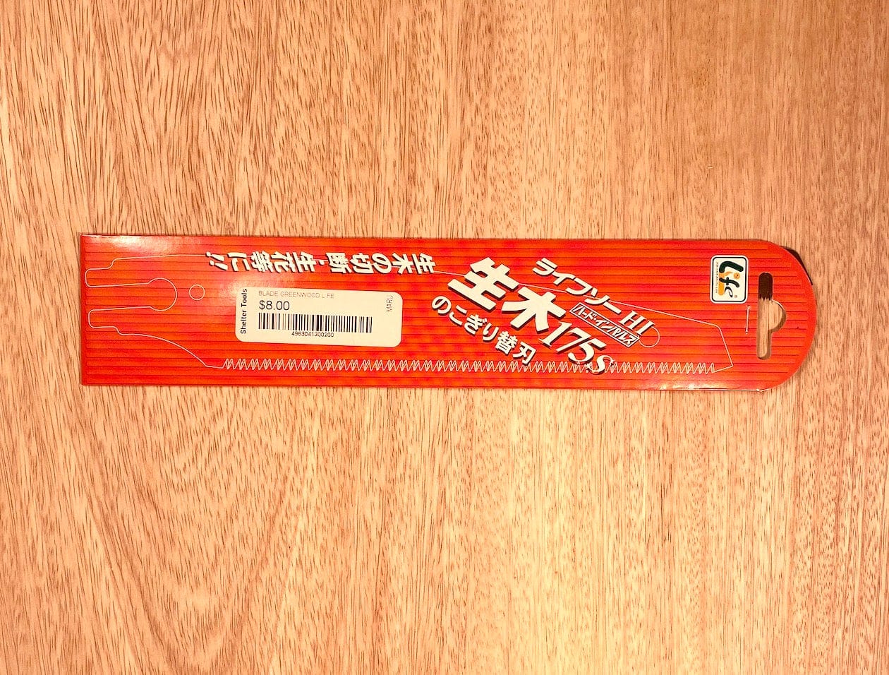 A MARU Z-Saw Universal 175 Green Wood Pruner, packaged in red with white Japanese text, sits on a wooden surface with a price tag of $8.00.