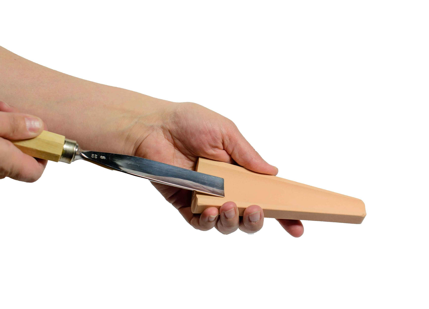 A person uses the MARU Cone Slip Stone, held in hand against a white background, to demonstrate precise gouge sharpening technique.