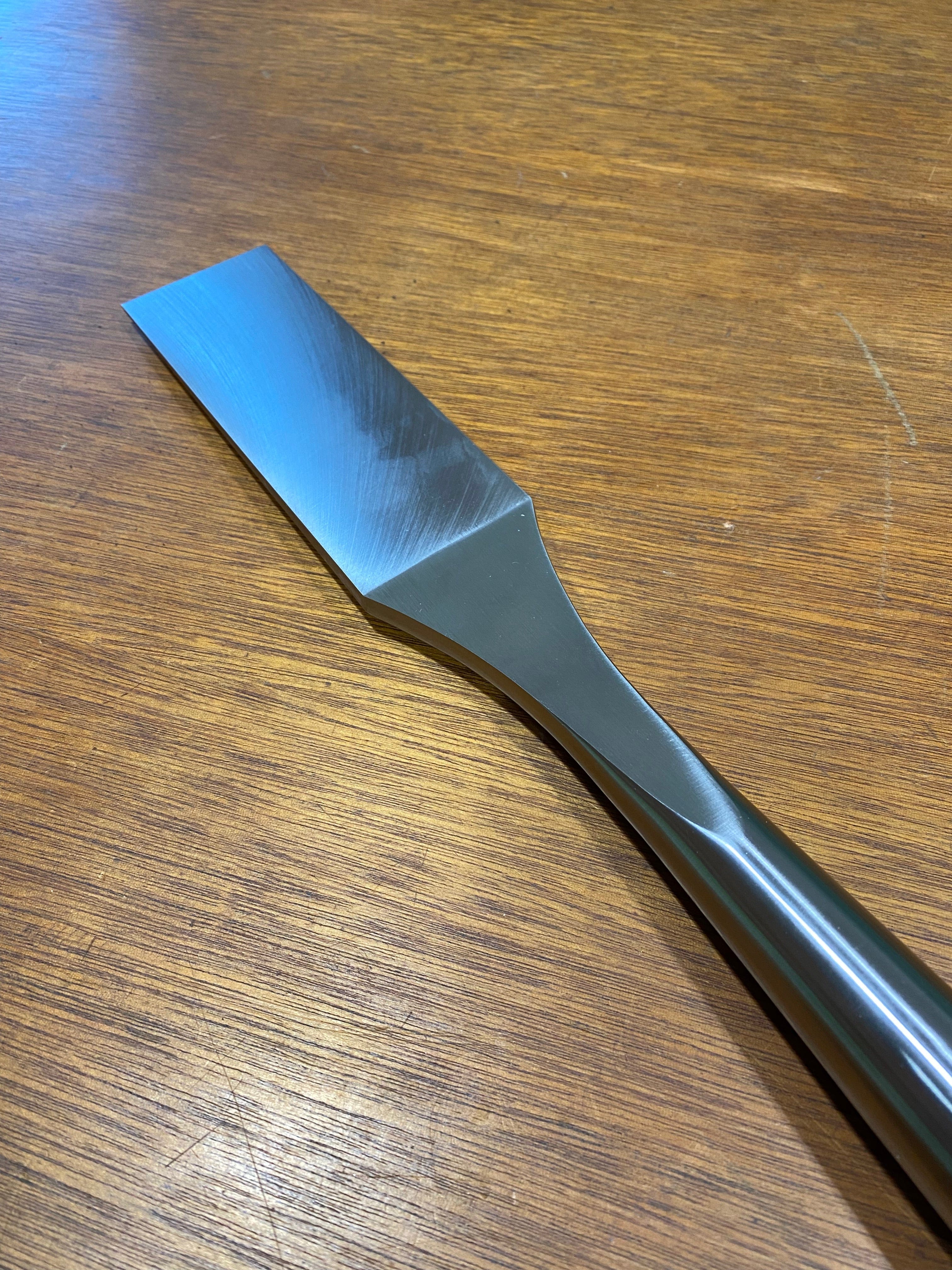 This woodworking tool, the MHG Timber Framing Slick, comes with a straight blade that rests on wooden surfaces, making it ideal for precise timber framing slick tasks.