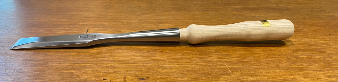 The MHG Timber Framing Slick, featuring a wood handle and high-alloy metal blade, rests on a wooden surface.