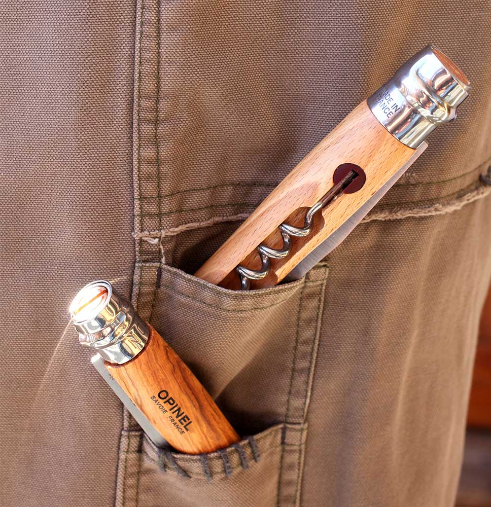 Two wooden-handled folding knives from Opinel are shown in a pocket. One is a standard stainless steel knife, and the other is the Opinel Knife featuring a professional-quality corkscrew attachment.