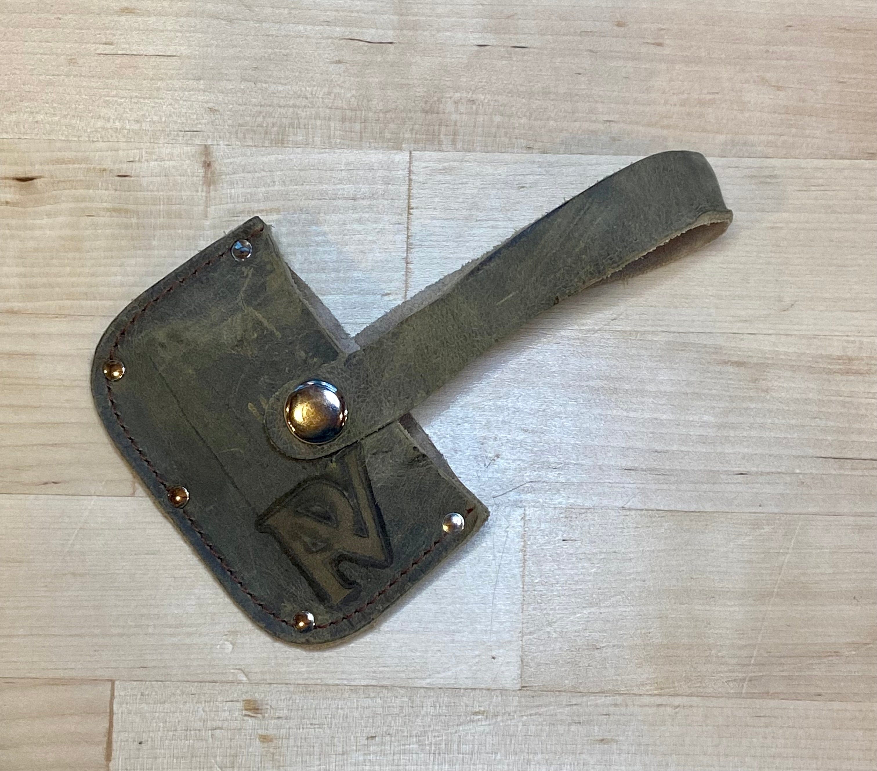 The Peavey Mini Splitting Maul by PEA rests on a light wooden surface—its rugged, hand-forged head and sturdy handle make it the perfect tool for camping gear and outdoor tasks. A bold PEA logo is stamped on the worn metal.