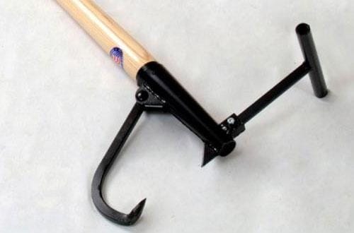 The PEA Peavey 2-3/8" X 42" Timberjack is a tool with a wooden handle, metal hook, and T-shaped grip, ideal for linemen and chainsaw tasks requiring secure gripping and pulling of objects.