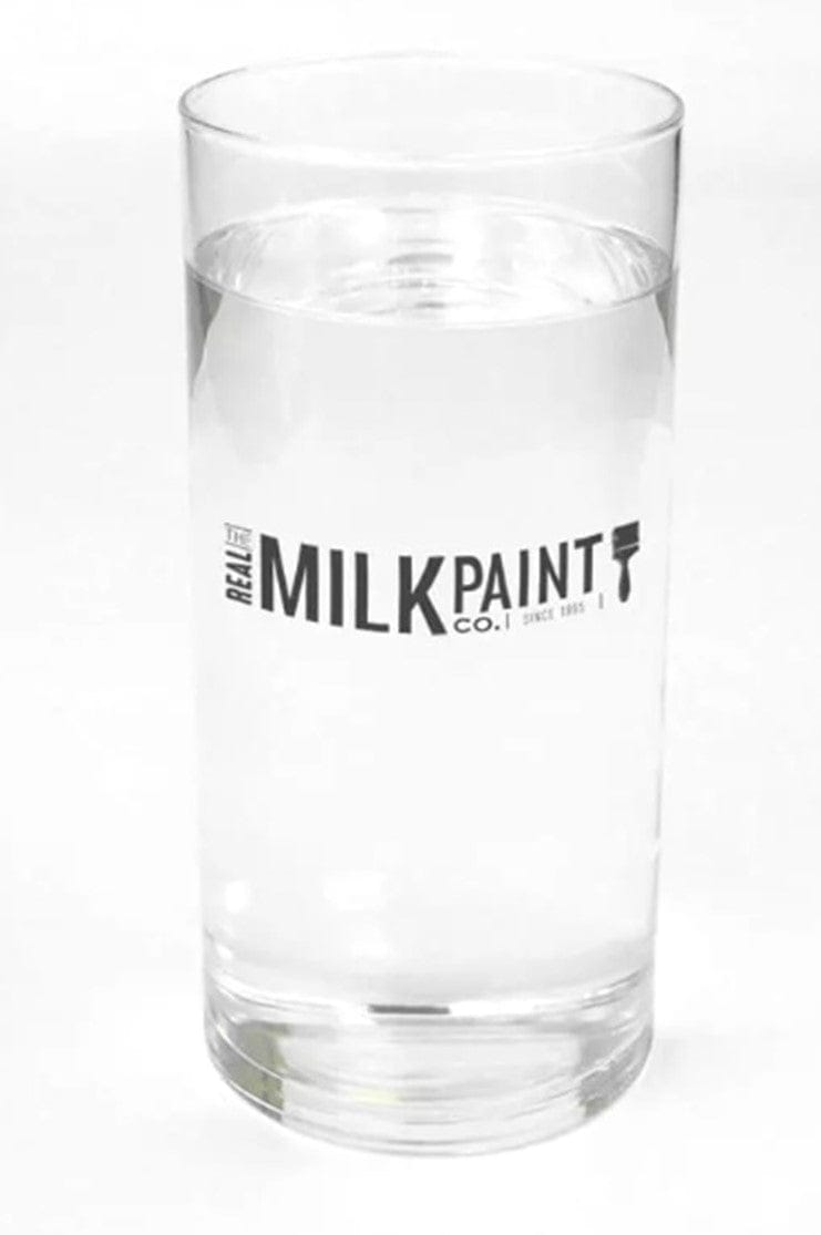 A transparent glass filled with clear liquid is labeled "RMP," showcasing their eco-friendly Citrus Solvent that also serves as a natural degreaser.