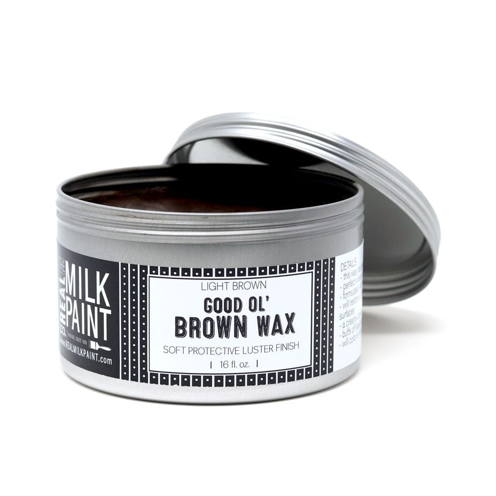 A silver tin labeled Good ol Brown Wax by RMP sits with its lid slightly open, showing light brown, soft finishing wax inside—perfect for adding protective luster to wood furniture.