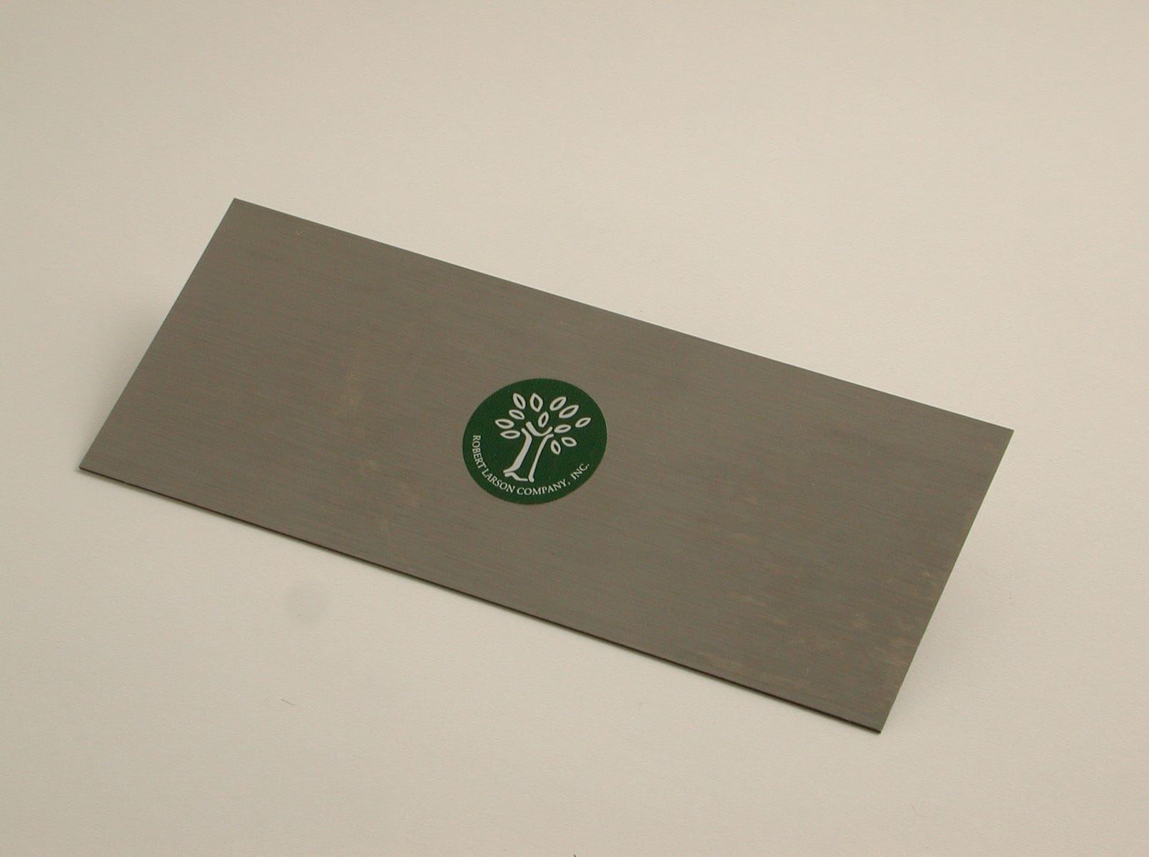 The Cabinet Scraper by ROB is a rectangular metal tool featuring a green circular sticker with a tree logo and the text "Brookstone Company Inc.," suggesting craftsmanship similar to German steel for durability and precision.