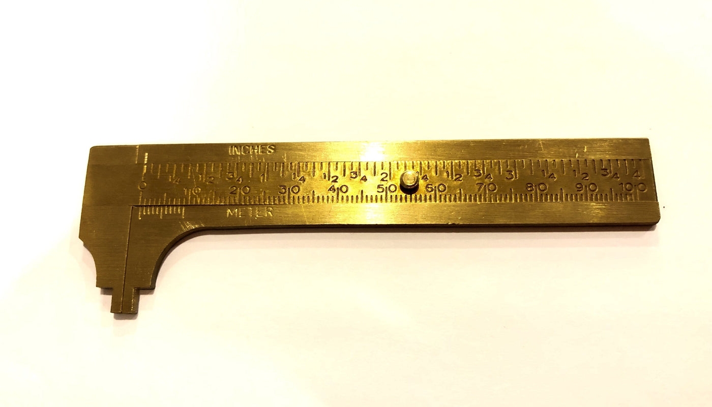 The ROB Brass Caliper is compact, featuring both metric (millimeters) and imperial (inches) measurements on a white background.