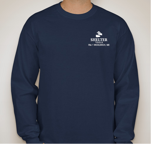 A person is wearing a Long-Sleeve Shelter Tools T-shirt from Shelter Institute. The shirt is navy blue with a custom design, featuring "Shelter Tools Rte 1 Woolwich, ME" and a logo printed on the left chest. It is made from 100% cotton.