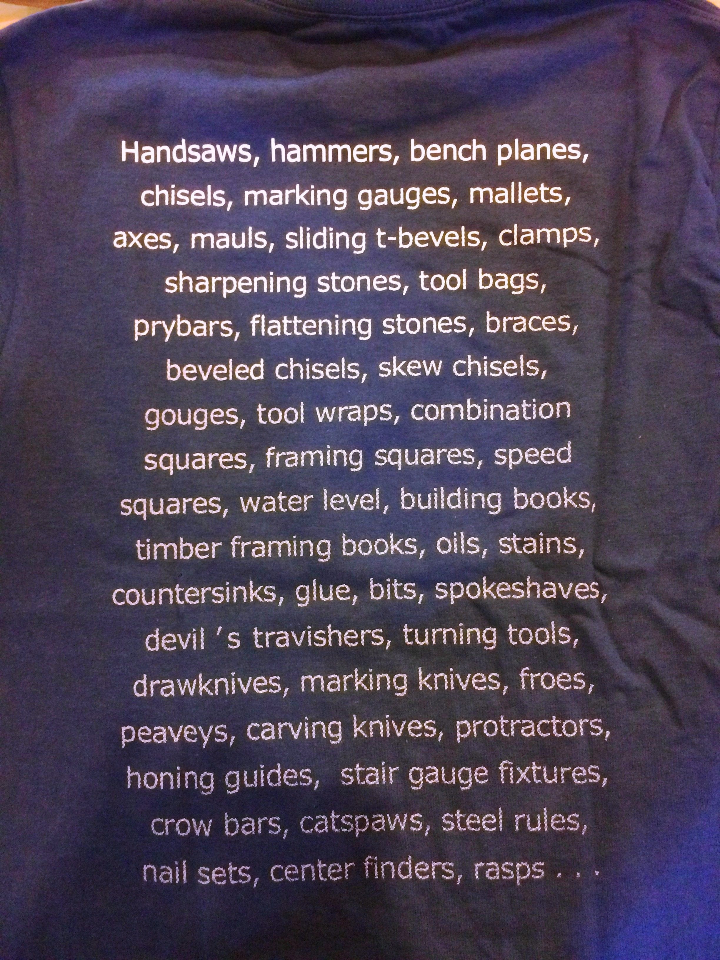 A close-up of the Long-Sleeve Shelter Tools T-shirt by Shelter Institute, showcasing a custom design with an extensive array of woodworking tools—handsaws, hammers, bench planes, chisels, marking gauges, and more—printed on the back in crisp white text.