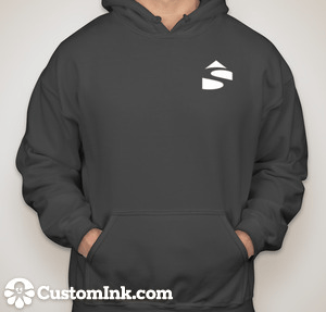 Person wearing a charcoal gray Shelter Institute Shelter Sweatshirt featuring a small white geometric logo on the upper left side and "CustomInk.com" in white text at the bottom. This lightweight poly/cotton blend hoodie effortlessly combines style and comfort.