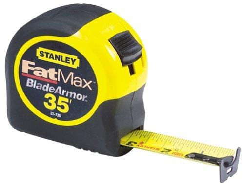 A close-up of an STN Stanley FatMax 35-foot tape measure showcases its durable rubber outer casing with the tape extended slightly. The predominantly black design is highlighted by yellow accents, and the text "Blade Armor" is visible on the side.