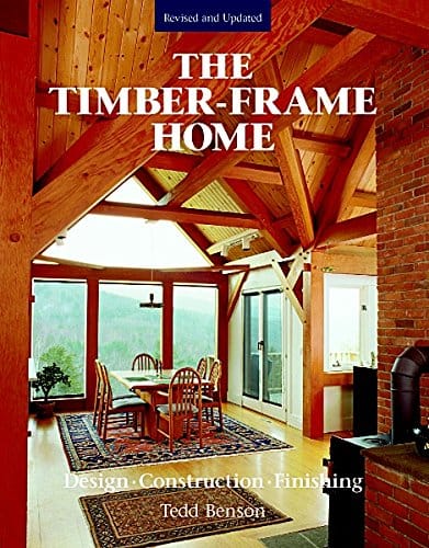 Cover of Taunton Press's "The Timber-Frame Home 2nd Edition," highlighting timber framing beauty with exposed beams, a dining table, chairs, and large windows inviting natural light to enhance the rich materials.