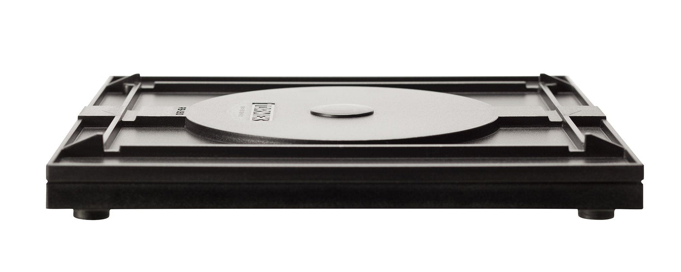 The Tormek Rotating Base by TOR features a black square metal design with a central circular section, crafted with precision comparable to sharpening a blade. It stands on four short legs, highlighting its sleek design and ensuring effortless use.