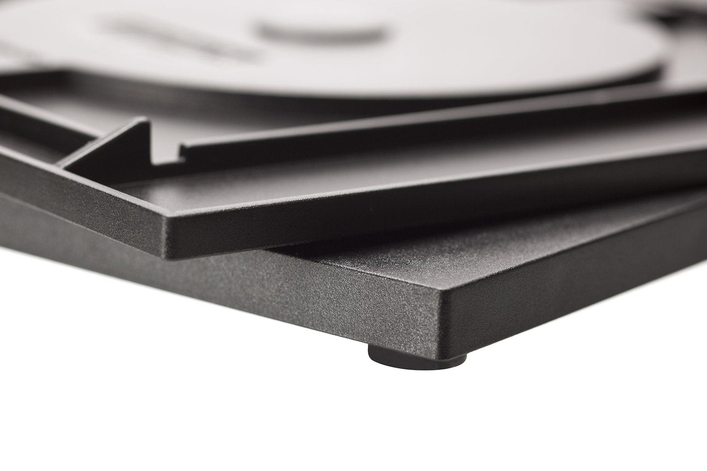 Close-up of a Tormek Rotating Base by TOR in black, showcasing a rotating platform and visible leveling foot, hinting at the honing precision achieved on the upper surface.