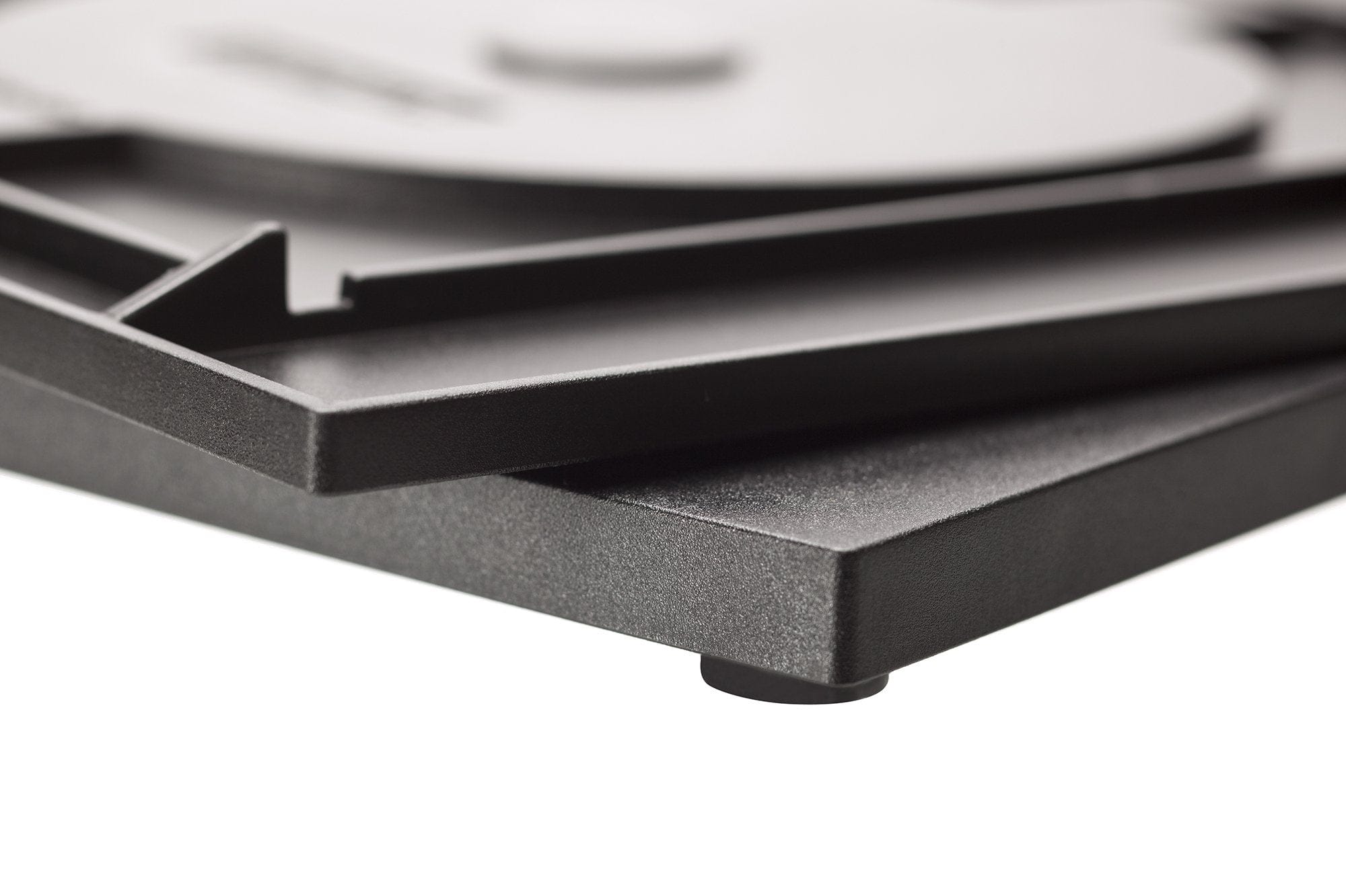 Close-up of a Tormek Rotating Base by TOR in black, showcasing a rotating platform and visible leveling foot, hinting at the honing precision achieved on the upper surface.