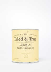 A can of TRD Tried & True Danish Oil Finish with a cream-colored label stands against a plain background, promising an exceptional finish for your wood stains.