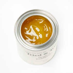 An open can of Tried & True Original Wood Finish from TRD, filled with a yellow, glossy liquid, perfect for interior wood protection.