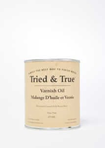 A beige can labeled "TRD Tried & True Varnish Oil Finish" features the text "Varnish Oil, Mélange D’Huile et Vernis." This premium wood finish is formulated with linseed oil, perfect for interior woodwork. Additional details are provided in smaller print.