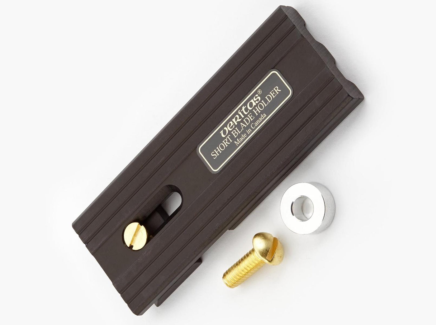 The VER Veritas Small-Blade Holder is a rectangular, dark anodized aluminum tool shown on a light surface with a gold screw, silver washer, and gold bolt arranged beside it.