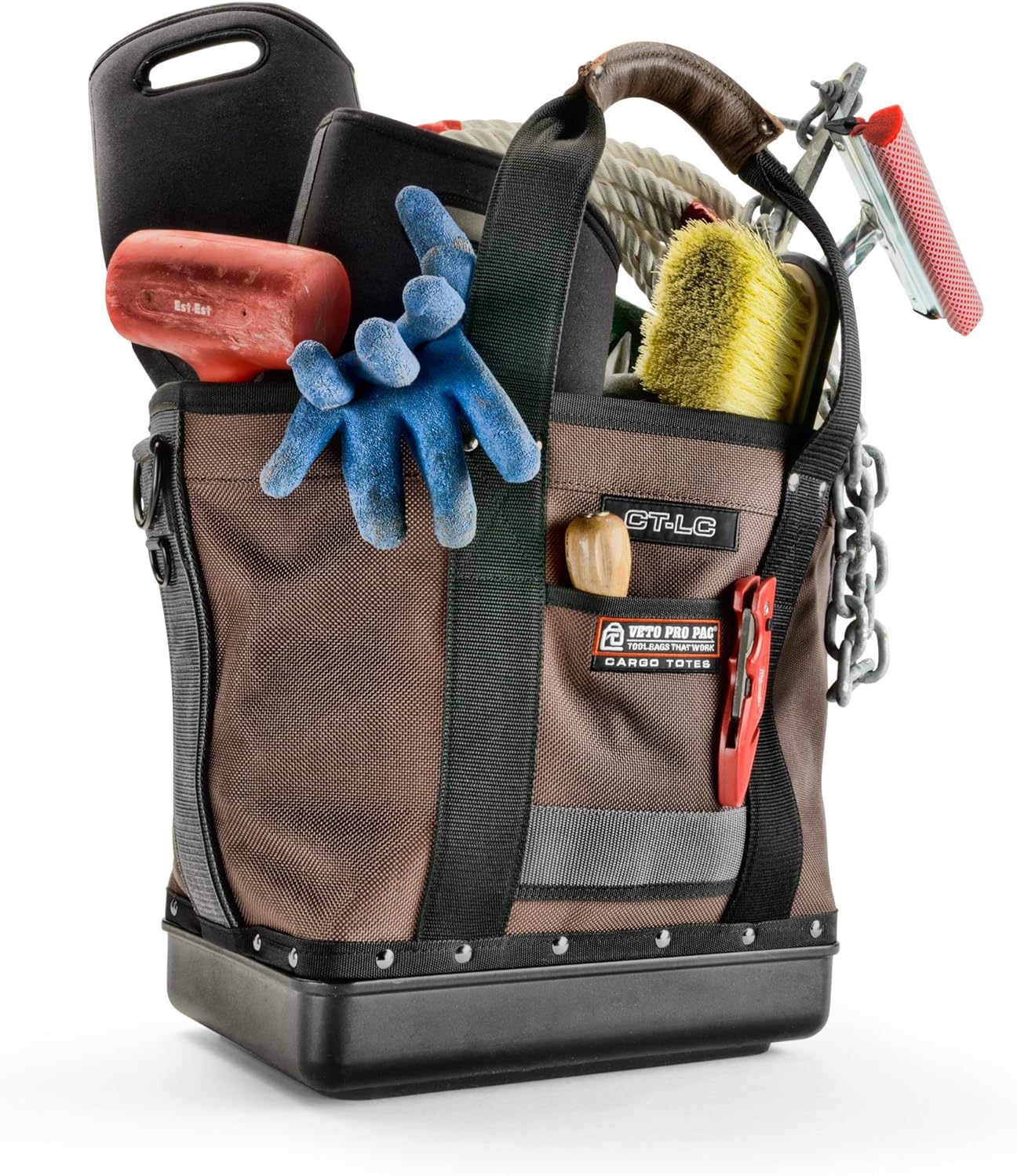 The VET Cargo Tote is a high-quality tool storage bag filled with essential equipment, including gloves, a rope, a brush, a hammer, and various other tools. Its rugged design features black straps and multiple compartments for organization. This brown cargo tote ensures durability and convenience on any job site.