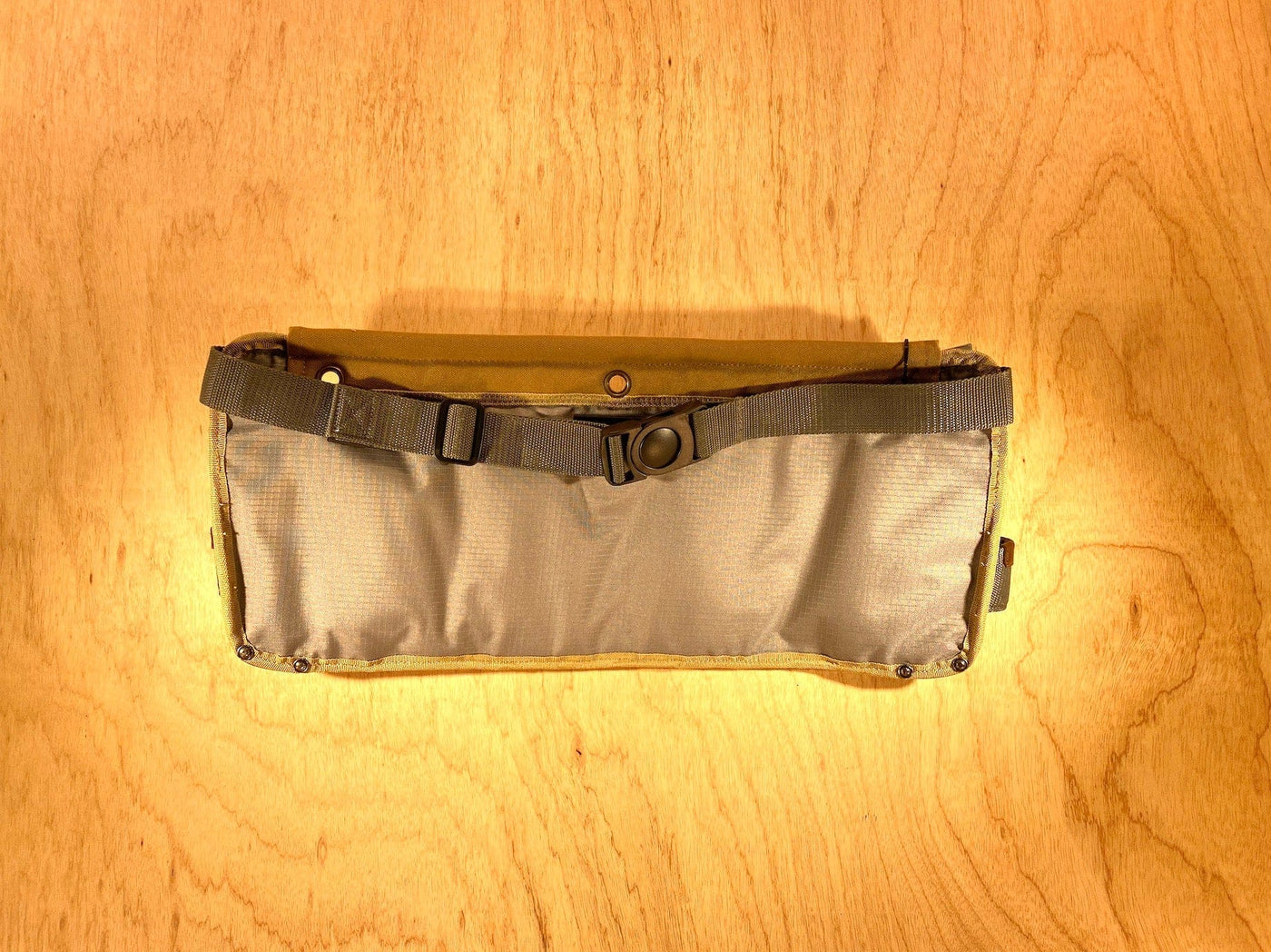 The VET Veto Pro Pac TA-WB Waist Apron, featuring a clip buckle strap for adjustable organization, is placed on a wooden surface.