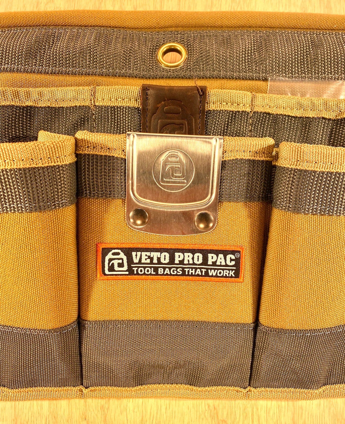 Close-up of a tan and gray Veto Pro Pac TA-WB Waist Apron by VET, designed for organized tool storage with multiple pockets and a metal clasp. The logo reads "Tool Bags That Work," embodying the ultimate tool carrying solution for professionals on the go.